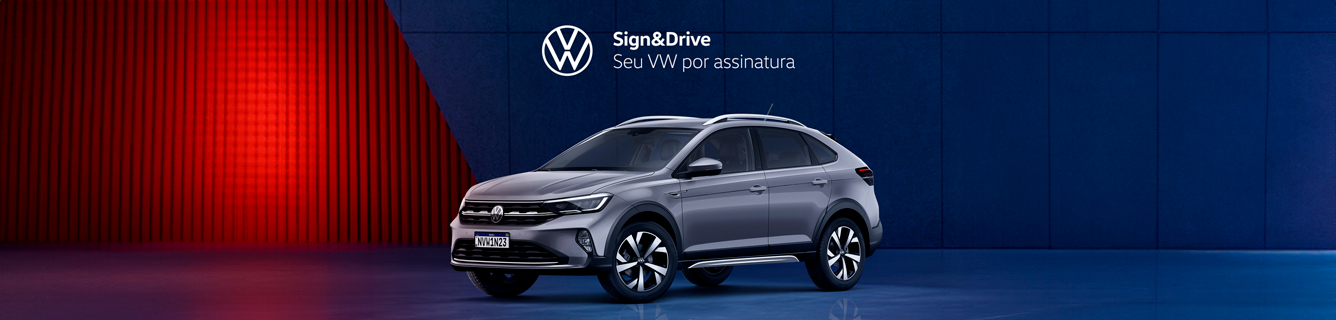 Um volkswagen prateado está estacionado em frente a uma parede azul.