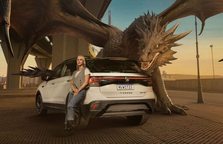 A woman is sitting on the back of a car next to a dragon.