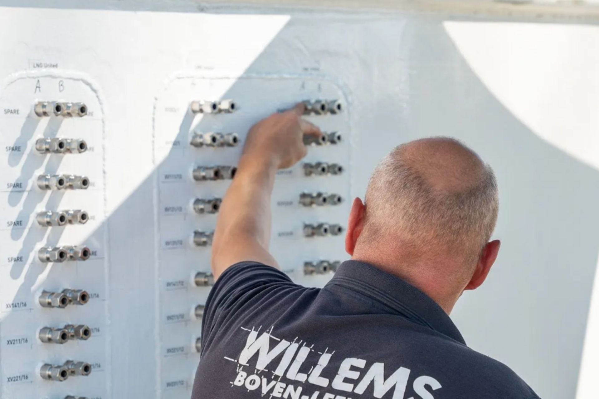 Een grote, zilverkleurige, veelzijdige metalen tankafdekking met een aangehechte toegangsladder, gelegen op een industrieterrein in de openlucht.