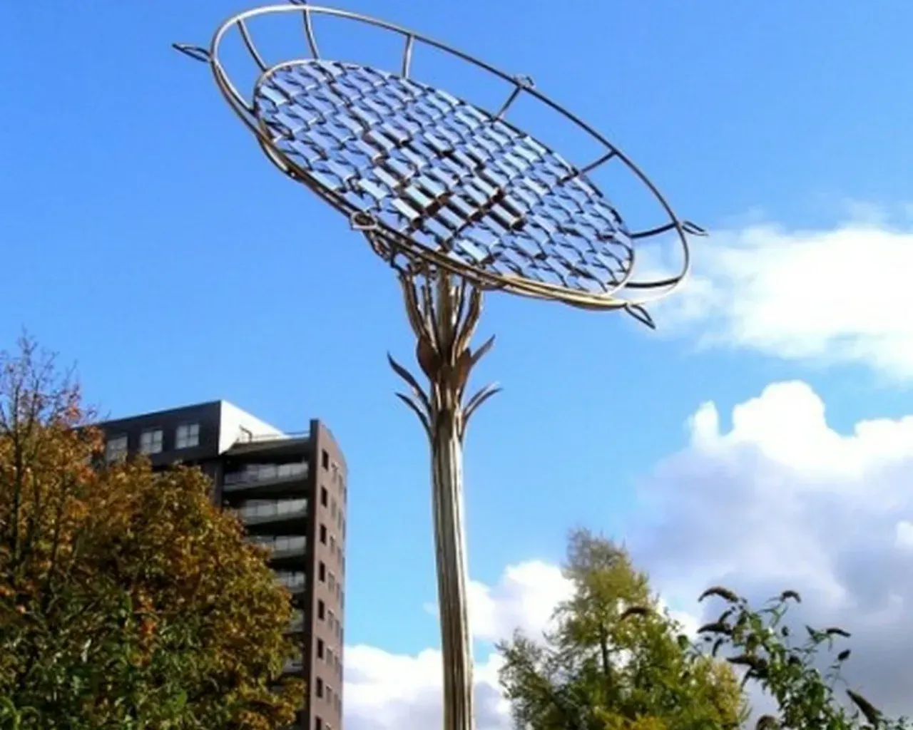 Een groot metalen beeld met een blauwe lucht op de achtergrond