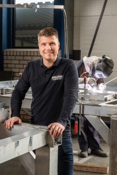 Een man staat voor een rij kleppen in een fabriek. Dirk Boekhorst.