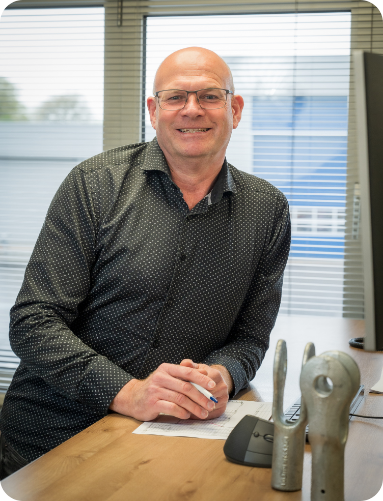 Een man staat voor een bureau met een toetsenbord en muis. Marcel van Baren