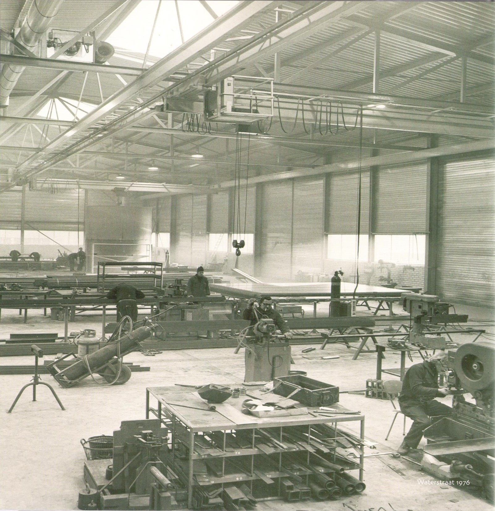 Een zwart-witfoto van een fabriek met een paar arbeiders Willems Boven-Leeuwen