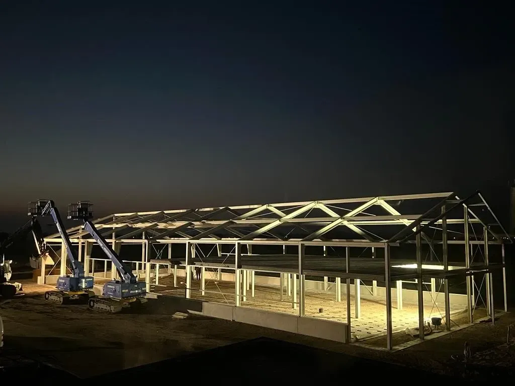 Een groot gebouw in aanbouw wordt 's nachts verlicht Door Willems Boven-Leeuwen.Door Willems Boven-Leeuwen.