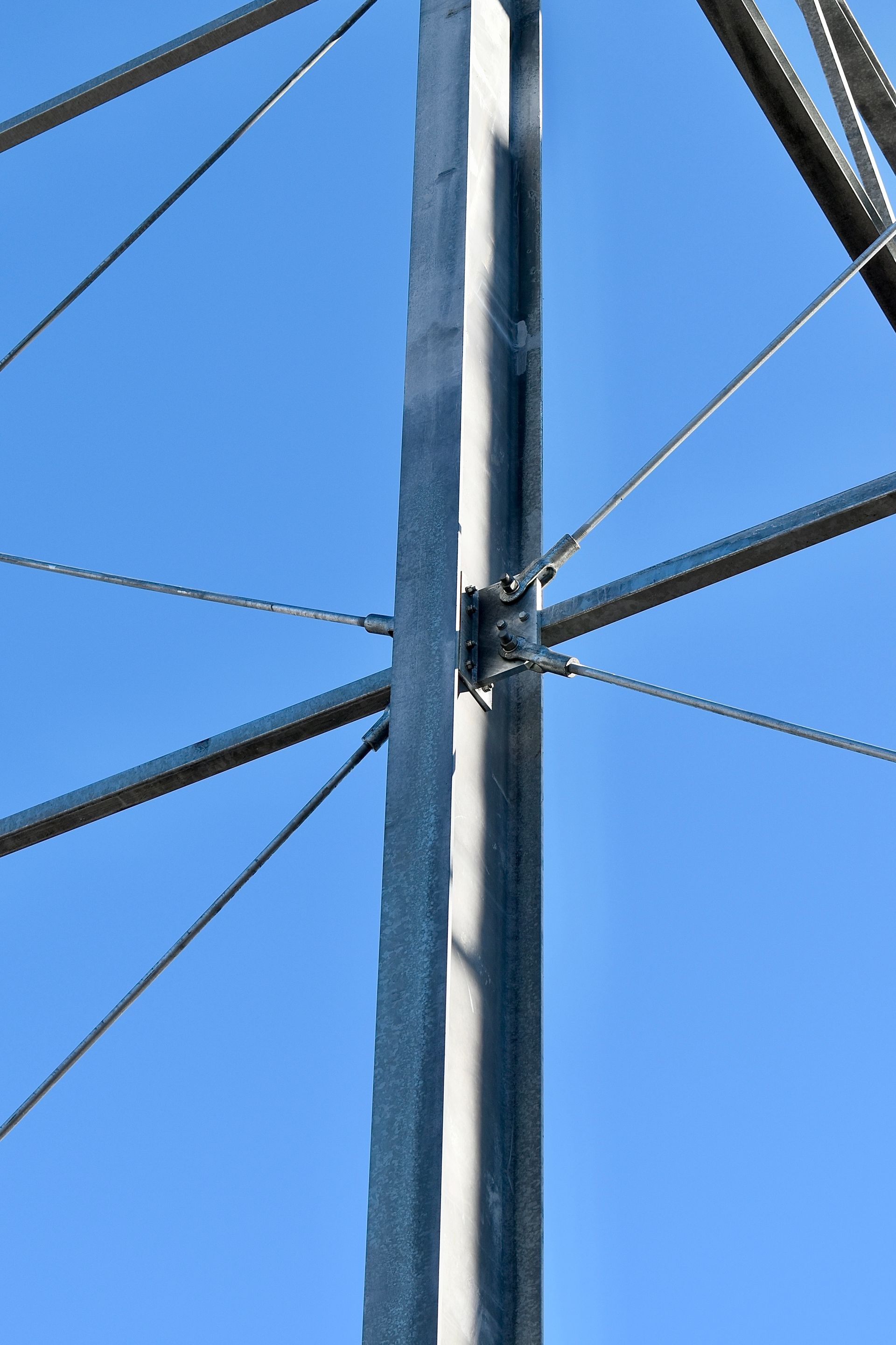 Een metalen paal met een blauwe lucht op de achtergrond. Willems Anker Windverband