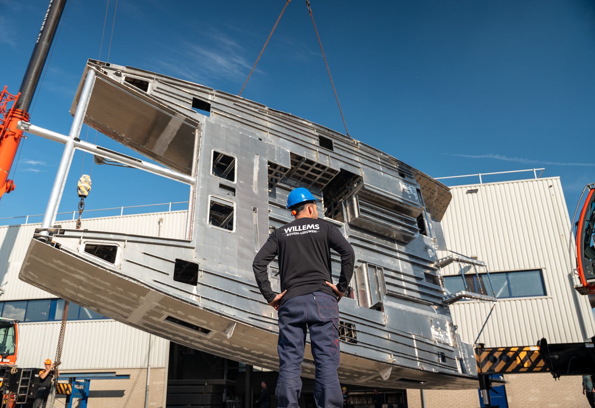In een fabriek wordt een grote roestvrijstalen boot gebouwd.