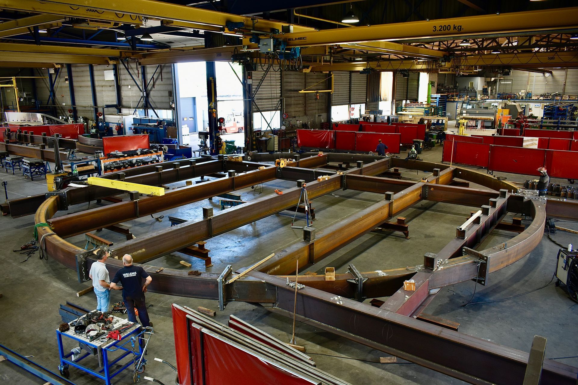 Een kraan en een jlg-lift werken aan een gebouw.
