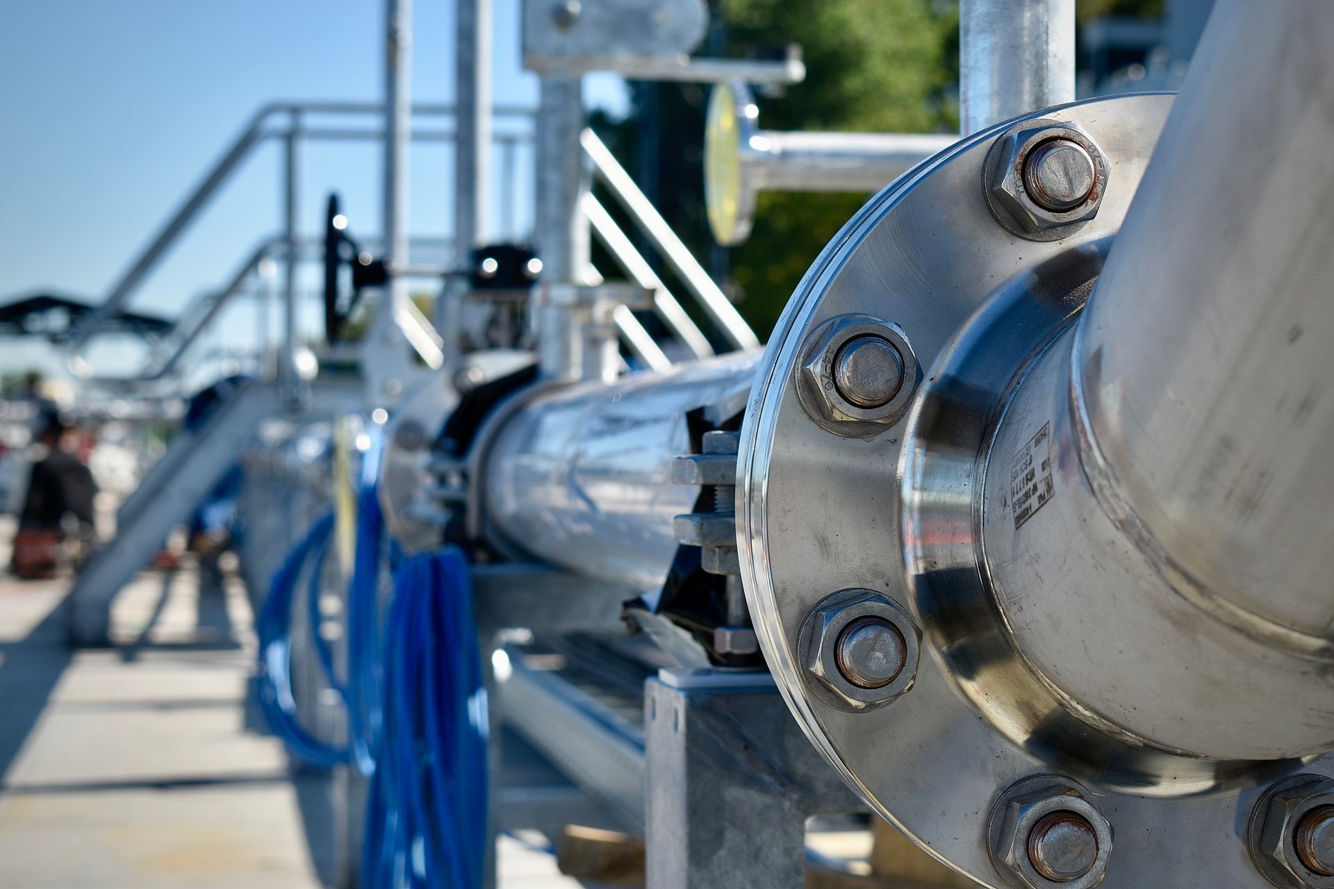 Een close-up van een roestvrijstalen buis met een flens erop.. Willems Piping & Equipment