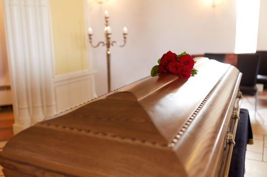 funeral casket with red roses