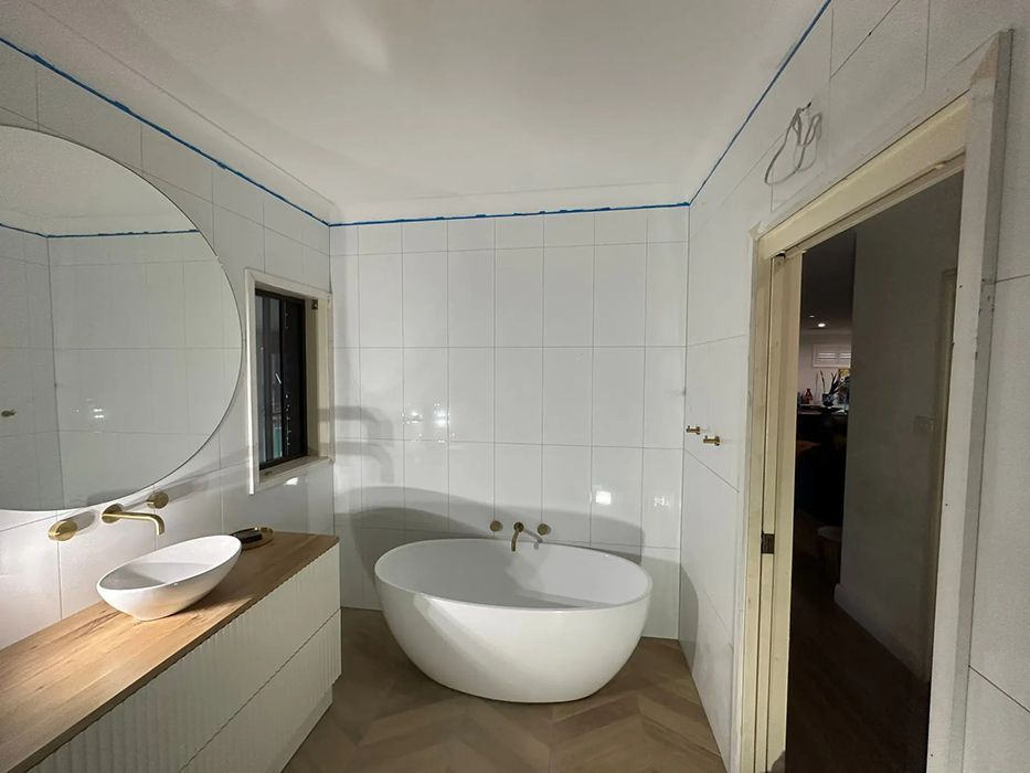 A Bathroom With A Bathtub, Sink And Mirror — Gordo's Plumbing Service In Wagga Wagga, NSW