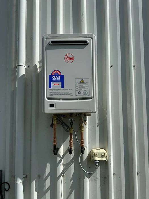 A Gas Water Heater Is Mounted On The Side Of A Building — Gordo's Plumbing Service In Wagga Wagga, NSW