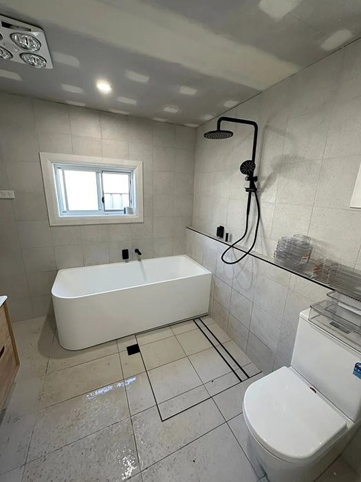 A Bathroom With A Bathtub, Toilet And Shower — Gordo's Plumbing Service In Wagga Wagga, NSW