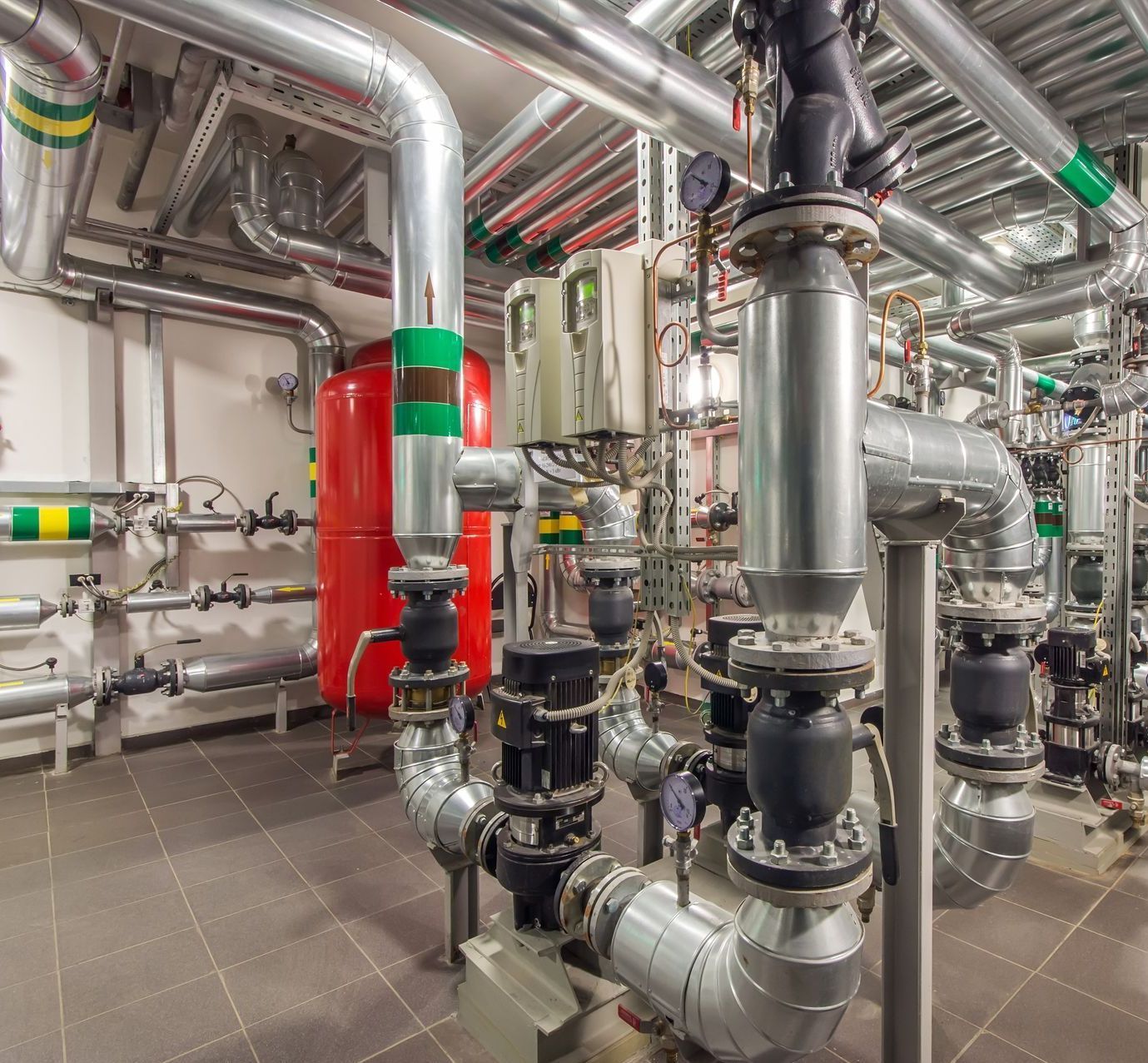 a room filled with lots of pipes and valves - a pump room of a large commercial building