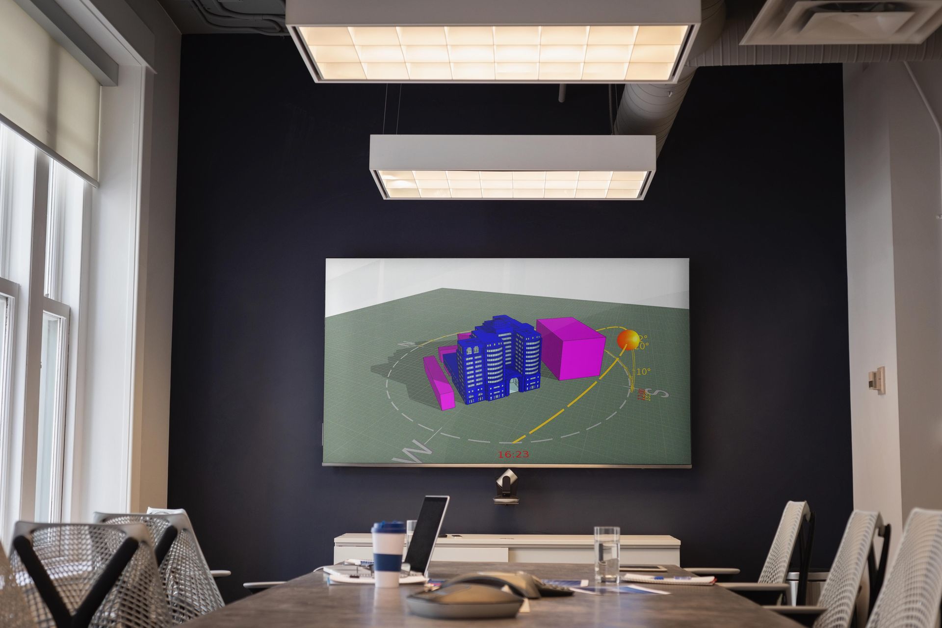a conference room with a drawing of a building on a screen on the wall