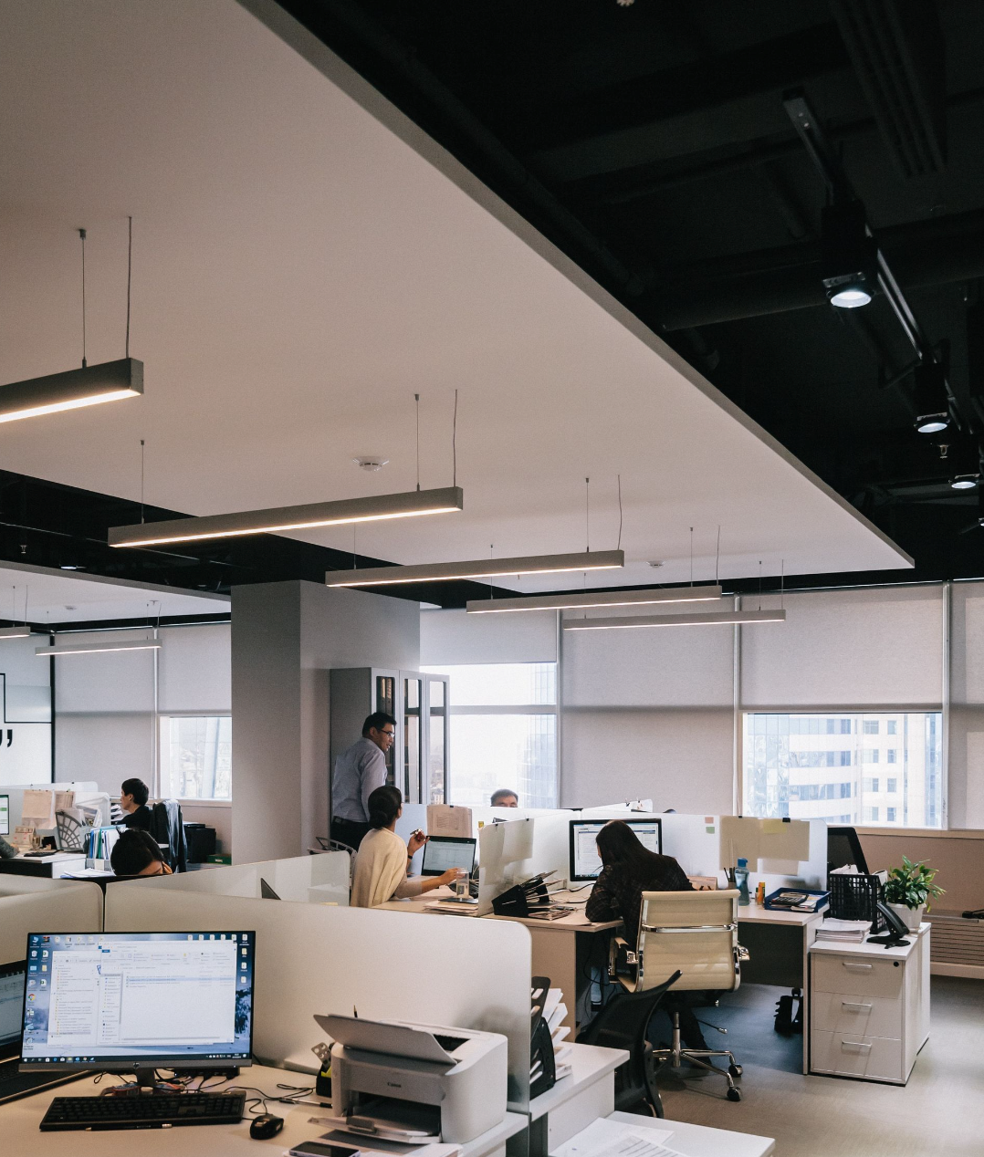 a group of people are sitting at desks in an office