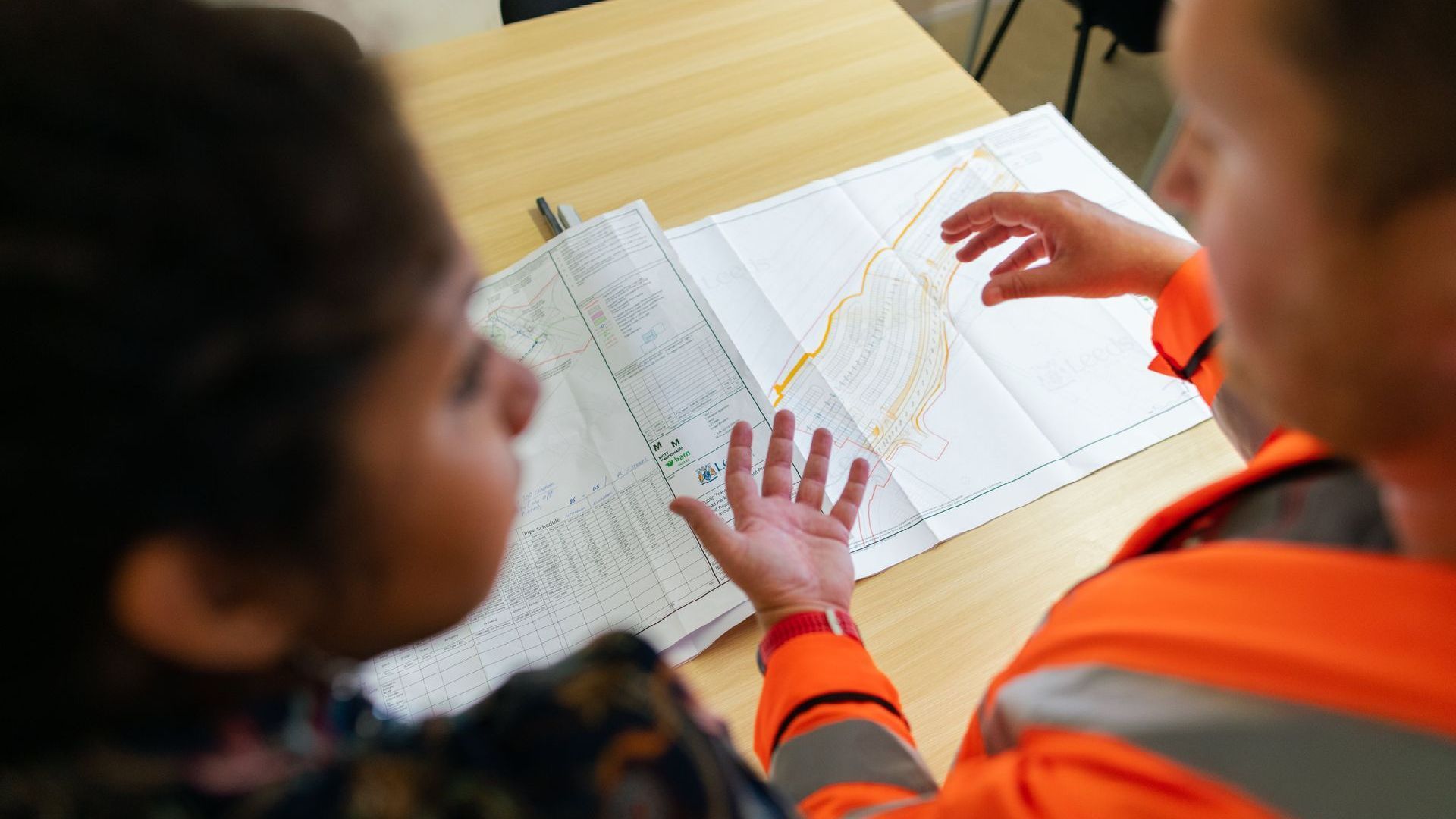 a man and a woman are looking at a map that shows a plan of a building on it