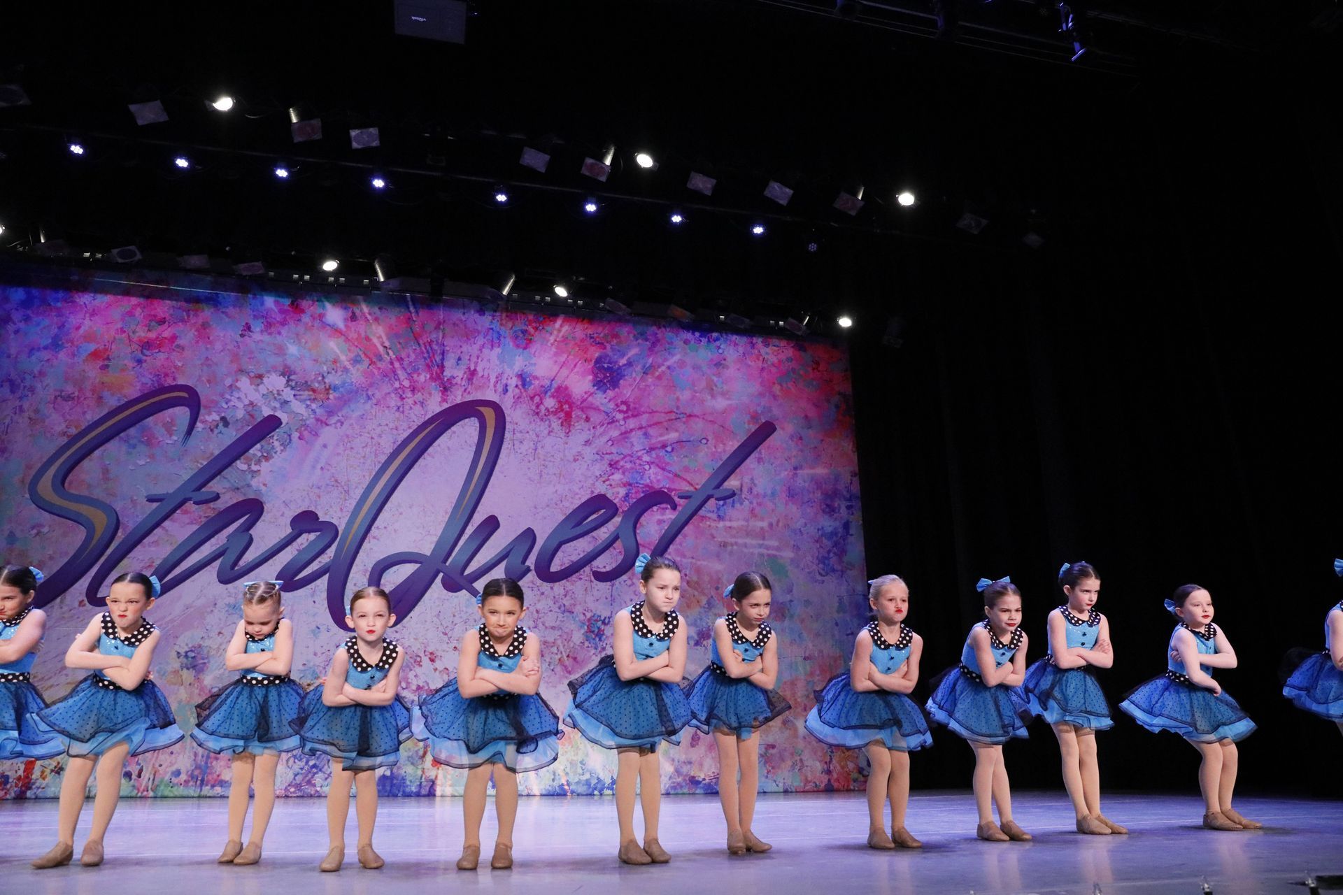 Group of girls in blue tutus performing a dance routine on stage near Fort Wright, KY