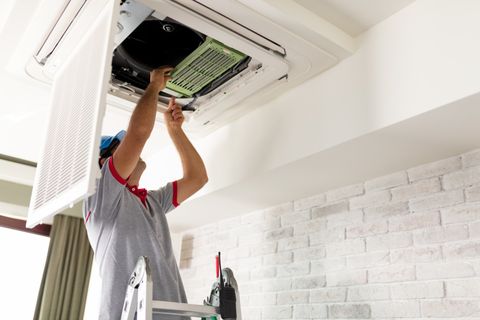Air Conditioning Repair — Man Repairing the Air Conditioner in Anniston, AL
