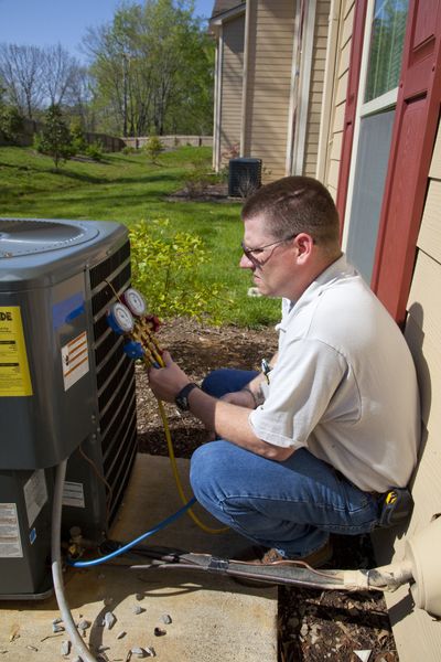 Air Conditioning — Man Fixing Air Conditioning in Anniston, AL