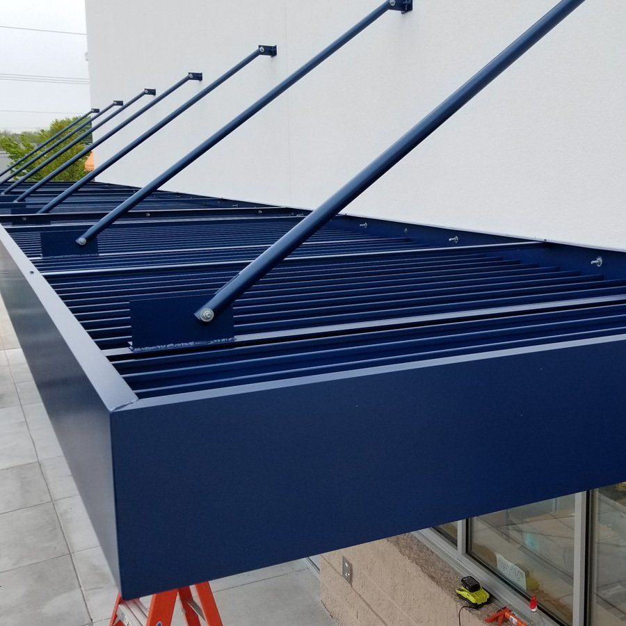 A blue awning is attached to the side of a building