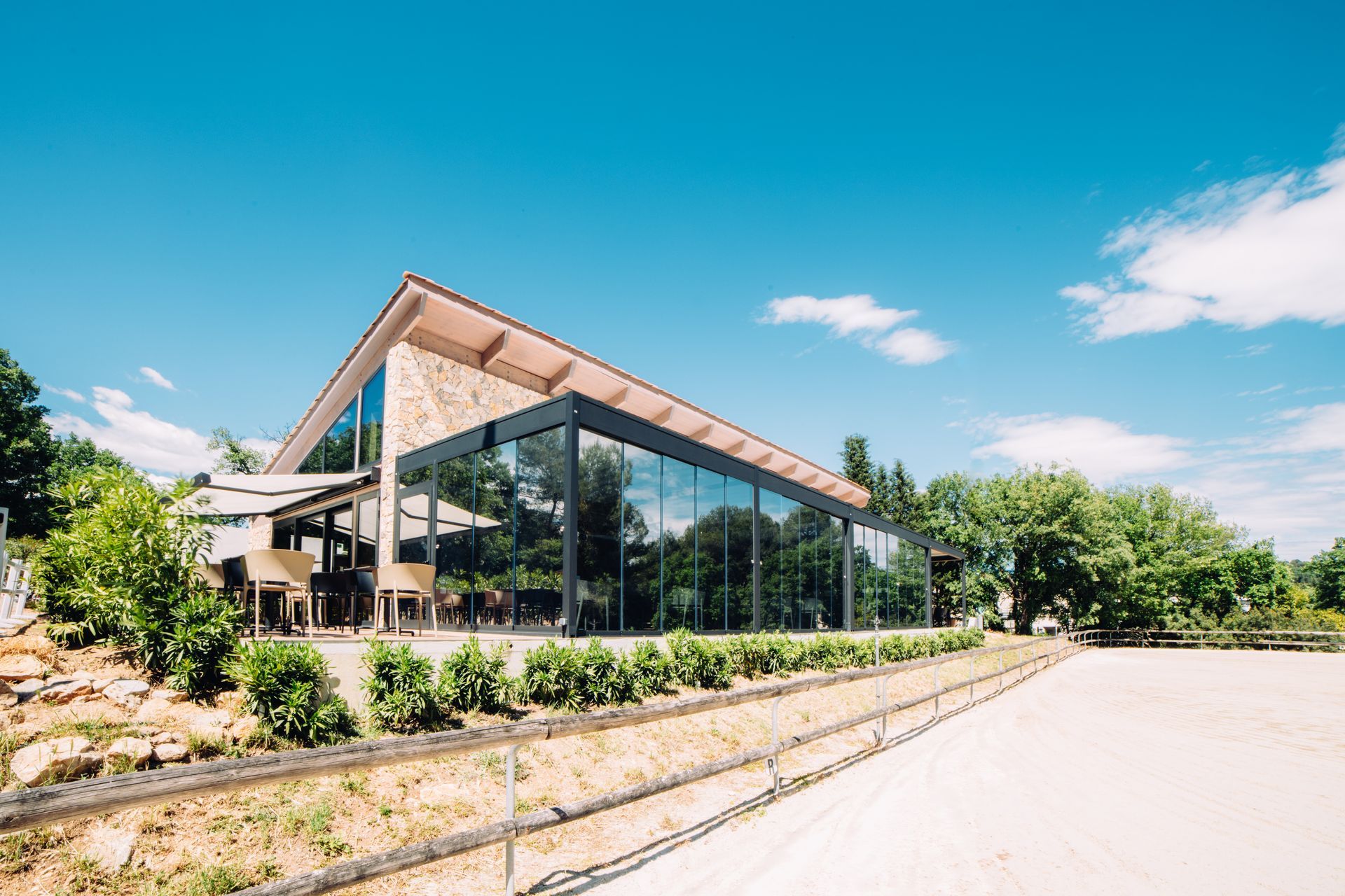 Trees surround a large building with a lot of windows - Freehold, NJ - Awning Design Inc