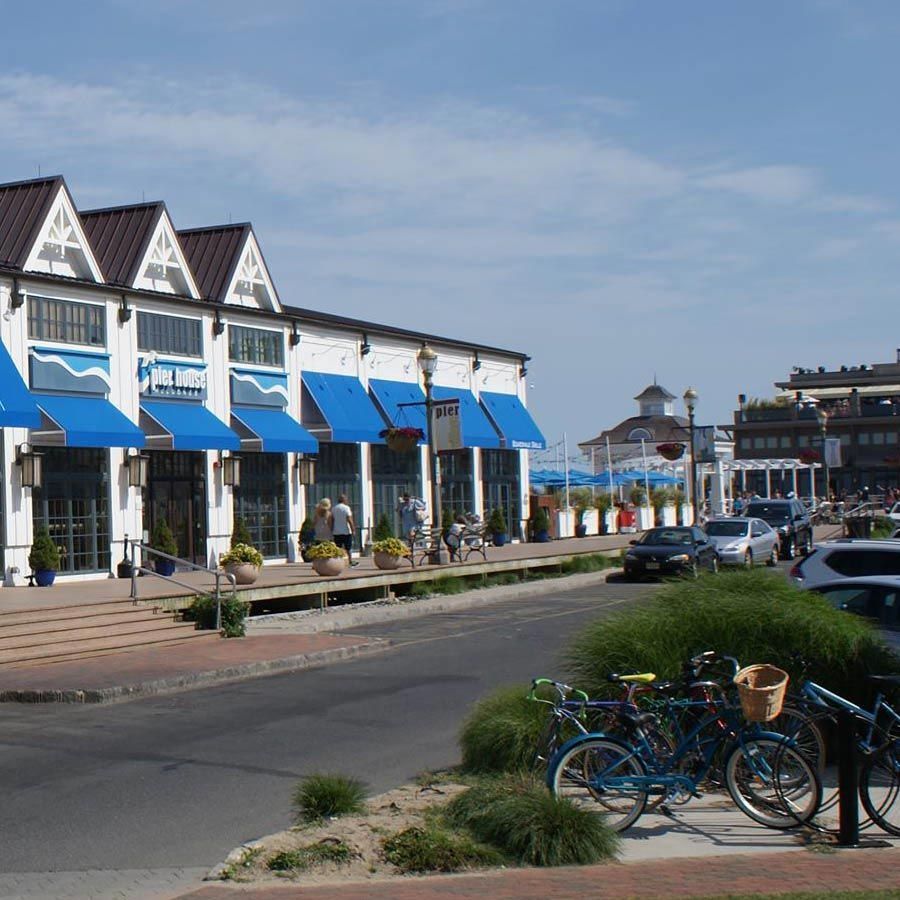 Bicycles are parked in front of a building with blue awnings