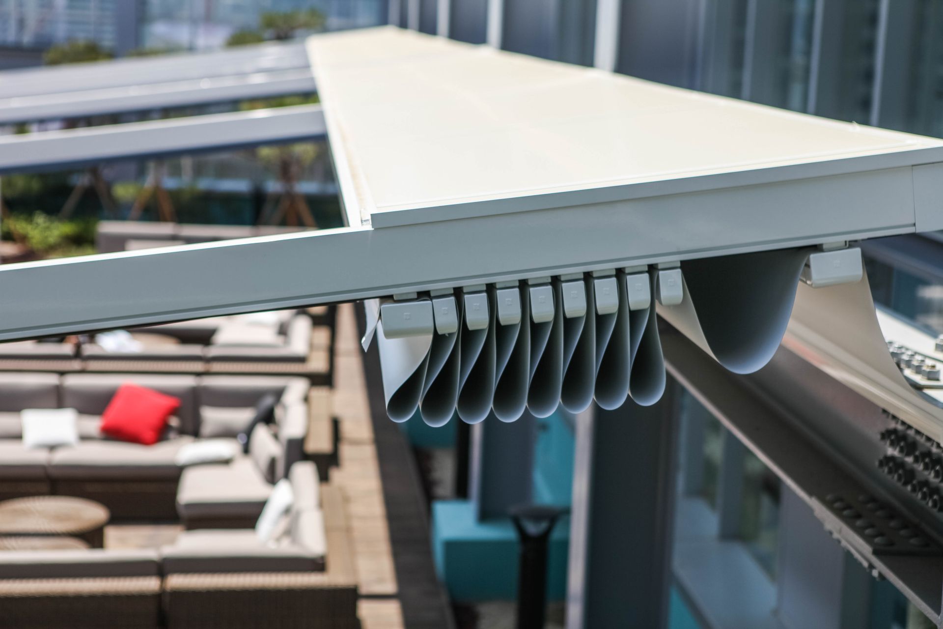 A white awning is hanging over a patio with a lot of furniture - Freehold, NJ - Awning Design Inc