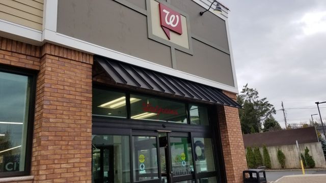 The front of a walgreens store with a black awning - Freehold, NJ - Awning Design Inc