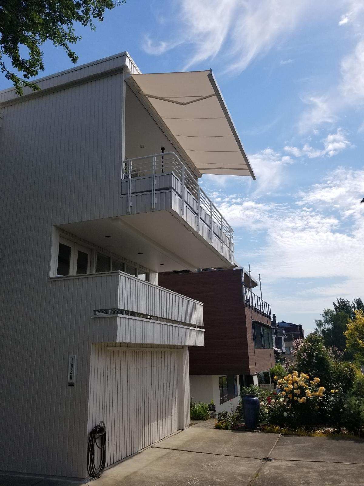 A large white house with a balcony and awning over it - Freehold, NJ - Awning Design Inc