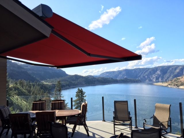 A red awning over a deck overlooking a lake - Freehold, NJ - Awning Design Inc