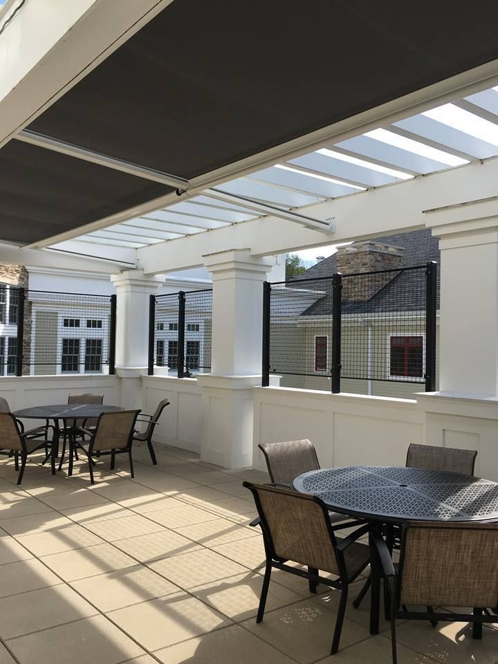 A patio with tables and chairs under a canopy