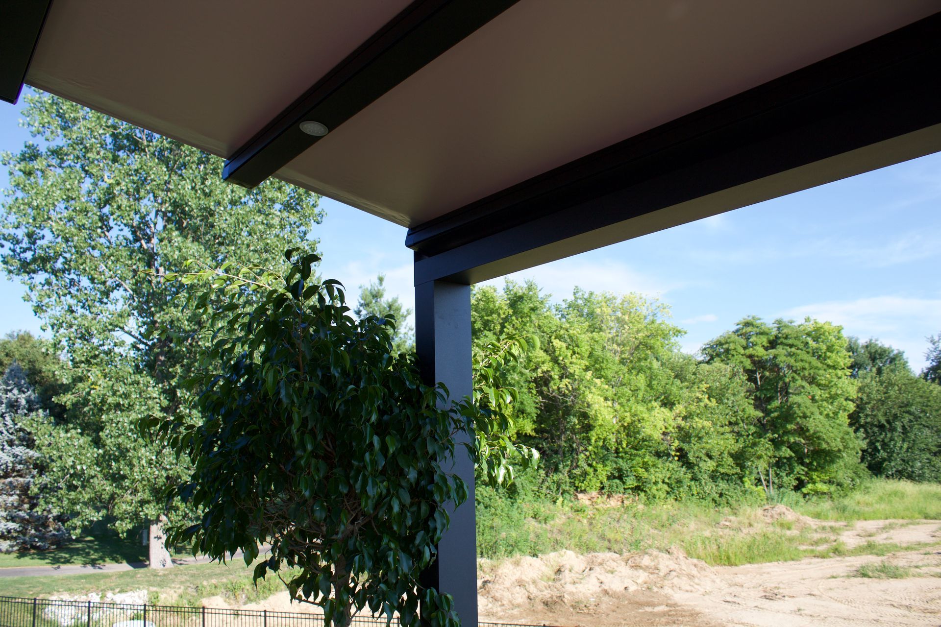 A covered porch with trees in the background - Freehold, NJ - Awning Design Inc