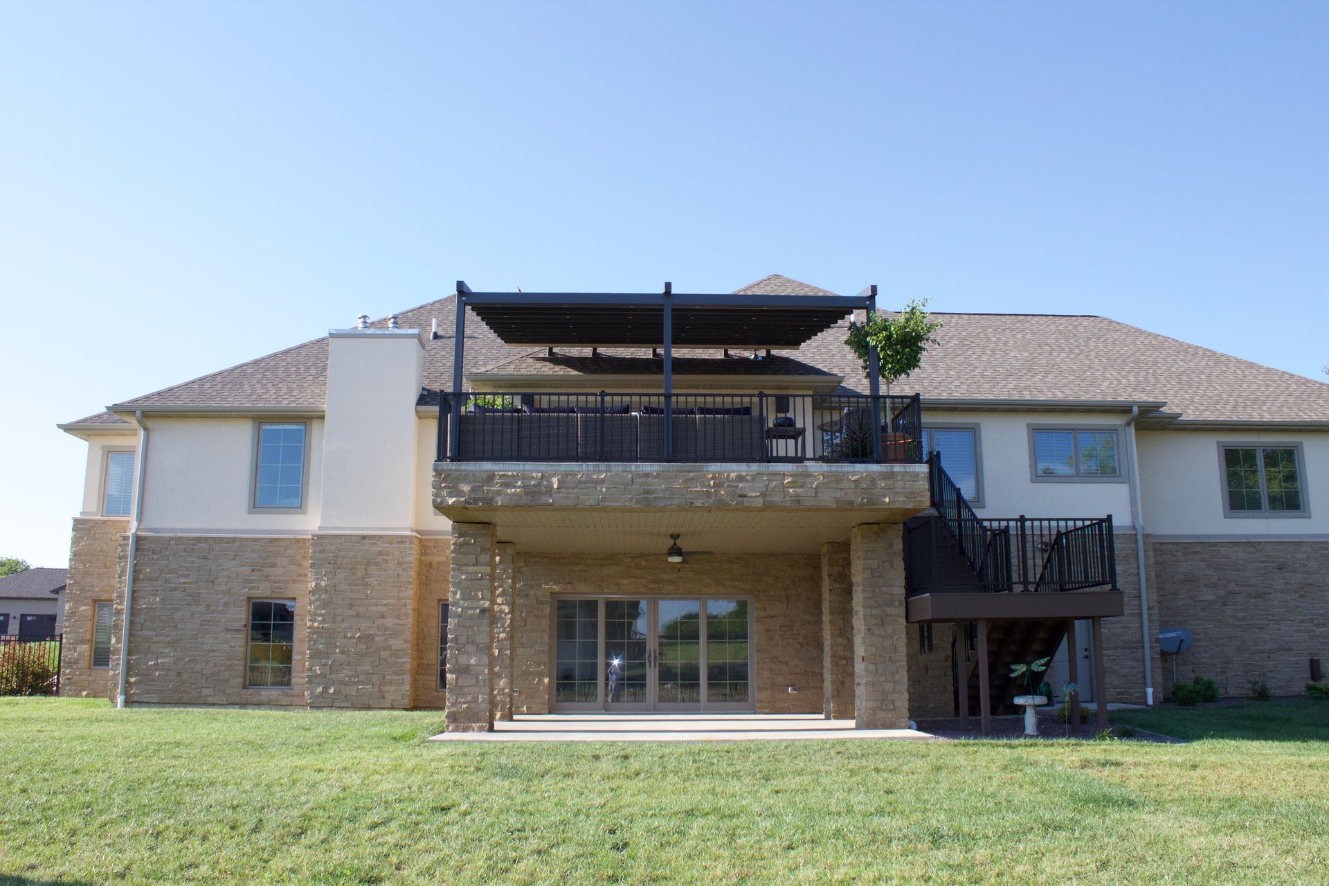 The back of a large house with a large balcony - Freehold, NJ - Awning Design Inc