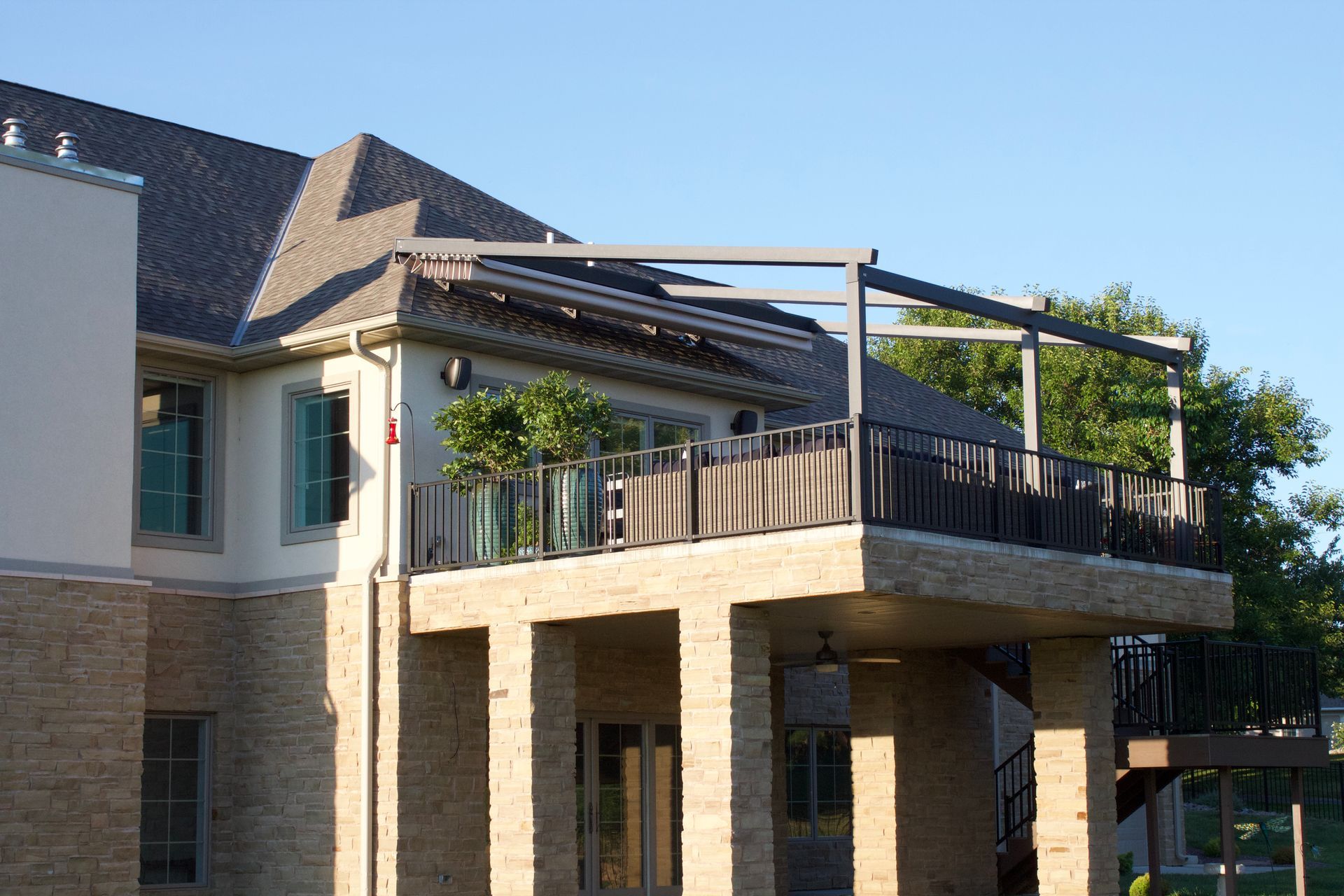 A large brick house with a large balcony - Freehold, NJ - Awning Design Inc