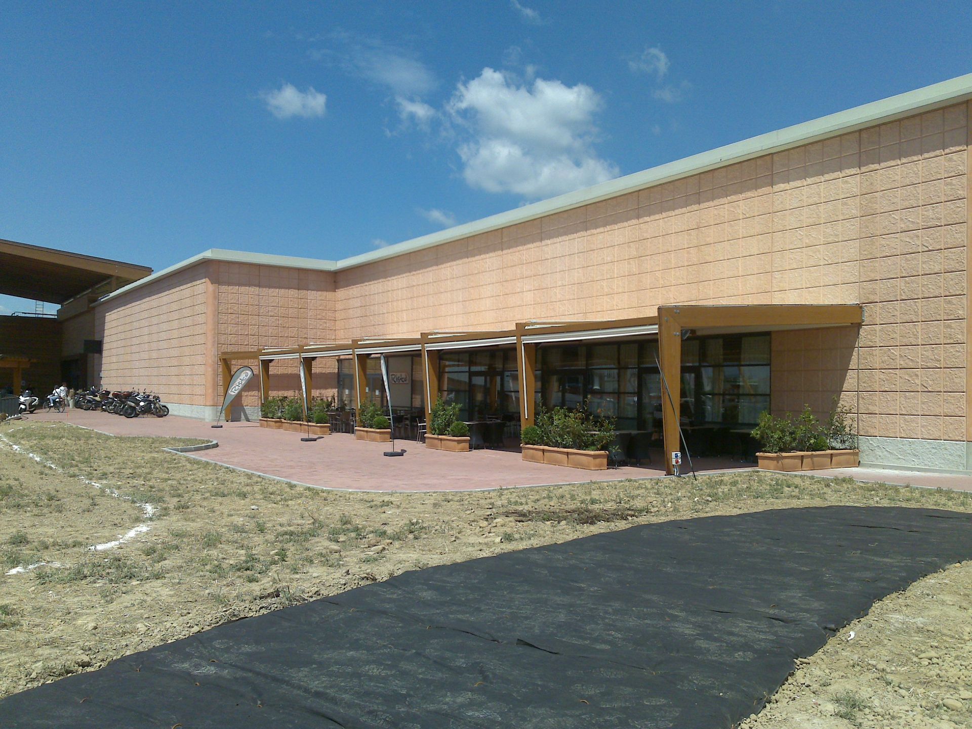 A large building with a lot of windows and planters in front of it - Freehold, NJ - Awning Design Inc