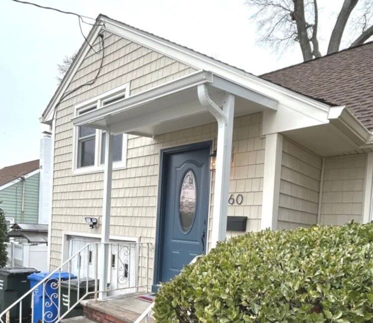 A white building with a window and a canopy over it - Freehold, NJ - Awning Design Inc