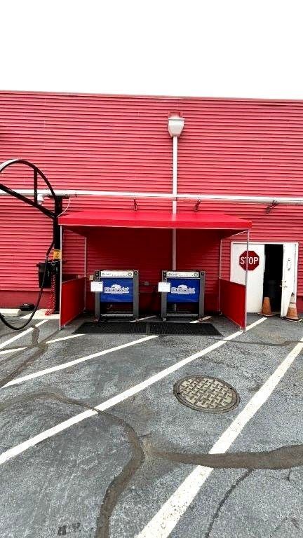 A red building with a parking lot in front of it - Freehold, NJ - Awning Design Inc
