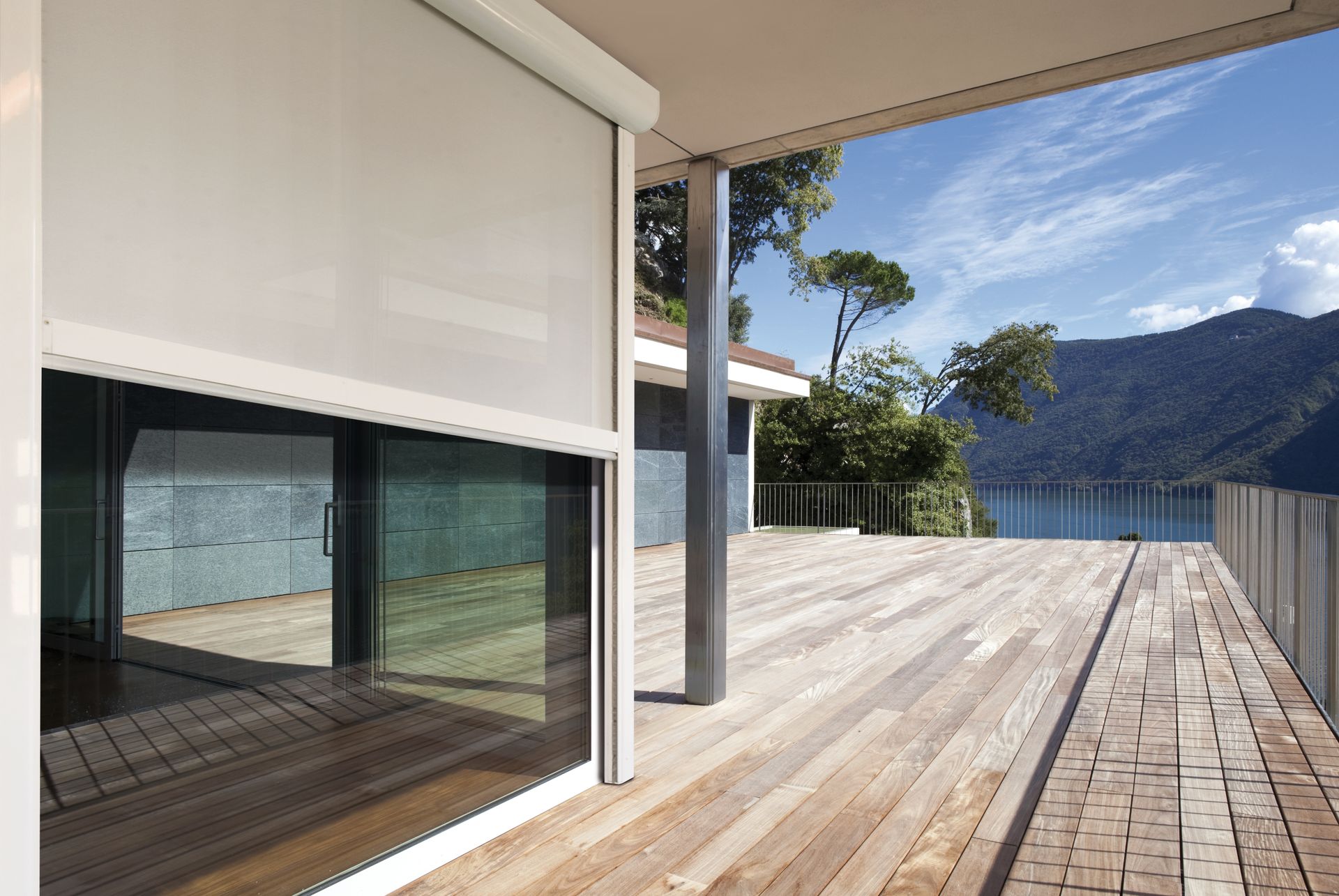 A wooden deck with a view of a lake and mountains - Freehold, NJ - Awning Design Inc