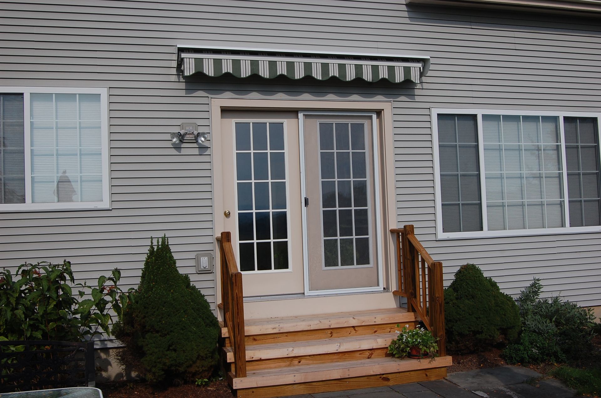 The front door of a house with a white awning over it - Freehold, NJ - Awning Design Inc