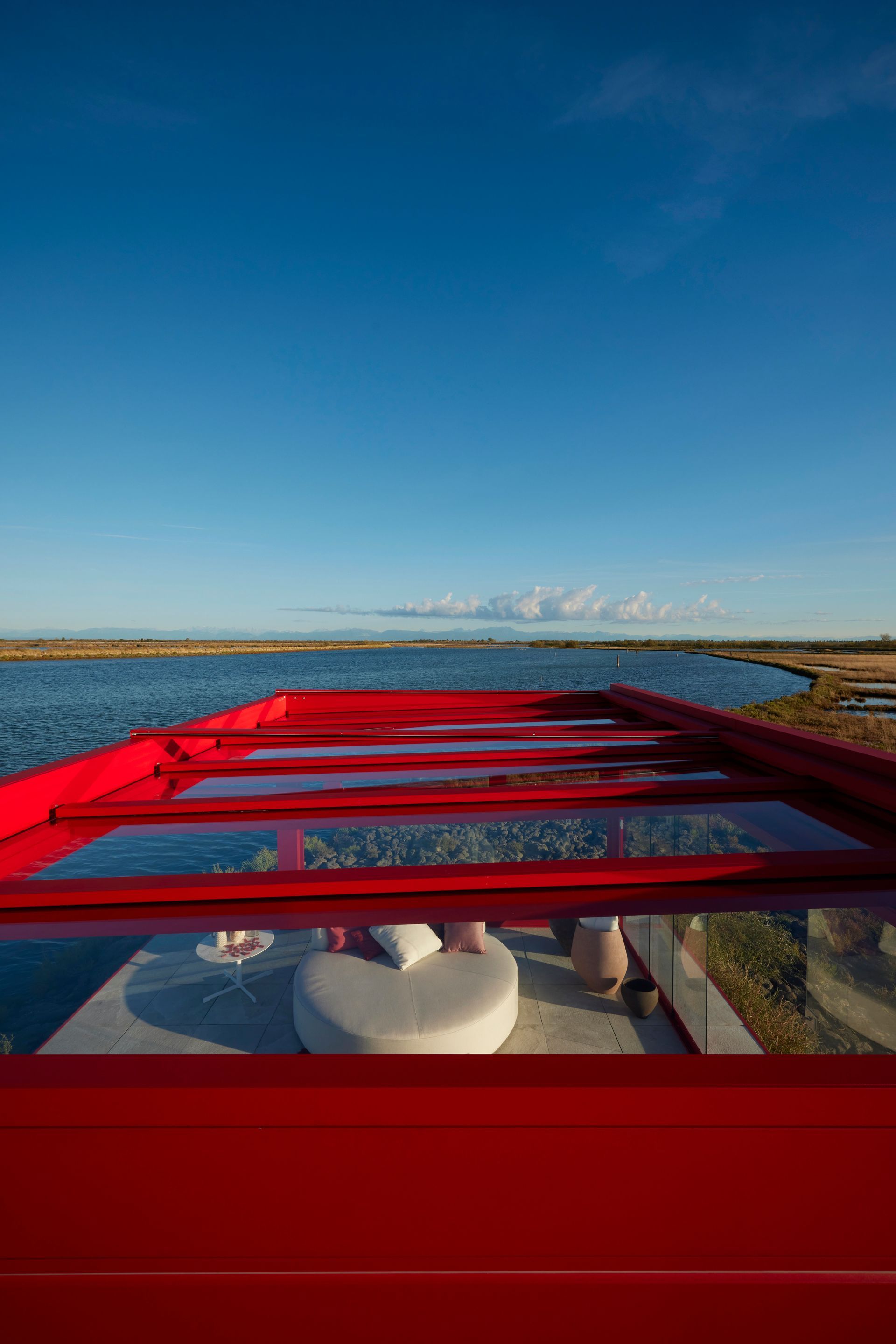 A red bridge over a body of water with a blue sky in the background - Freehold, NJ - Awning Design Inc