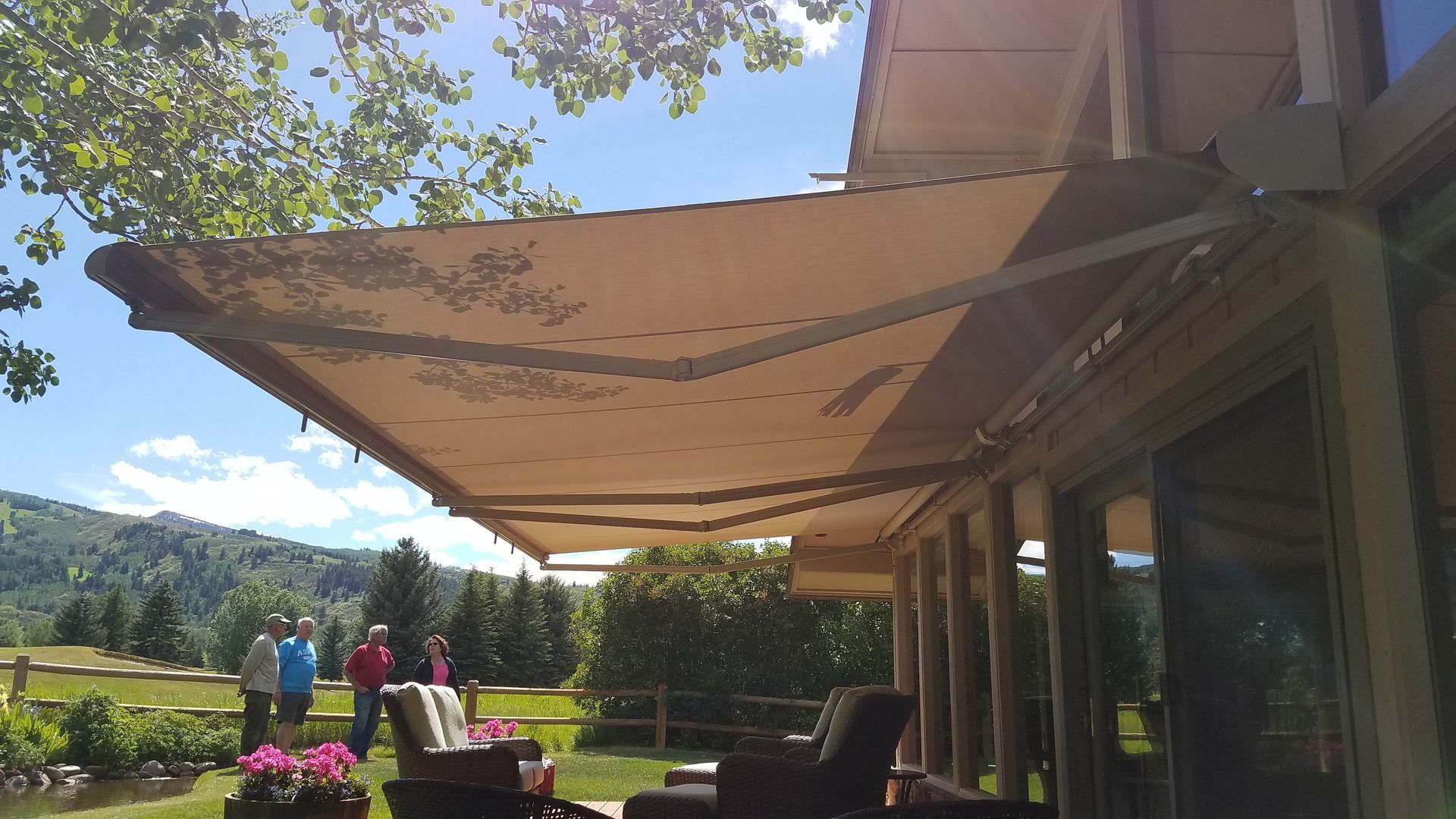 A group of people are standing under an awning on a patio - Freehold, NJ - Awning Design Inc