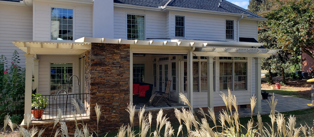 A large white house with a porch and a pergola - Freehold, NJ - Awning Design Inc