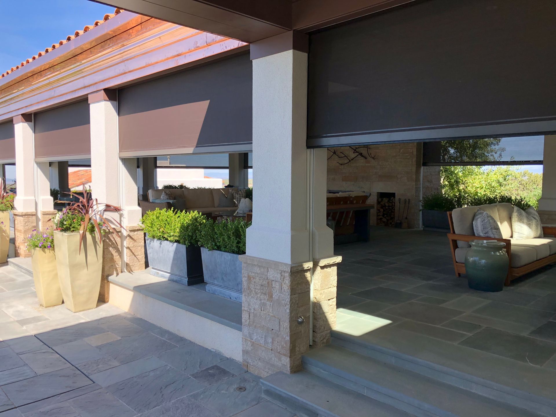 A patio with a couch and chairs and potted plants - Freehold, NJ - Awning Design Inc