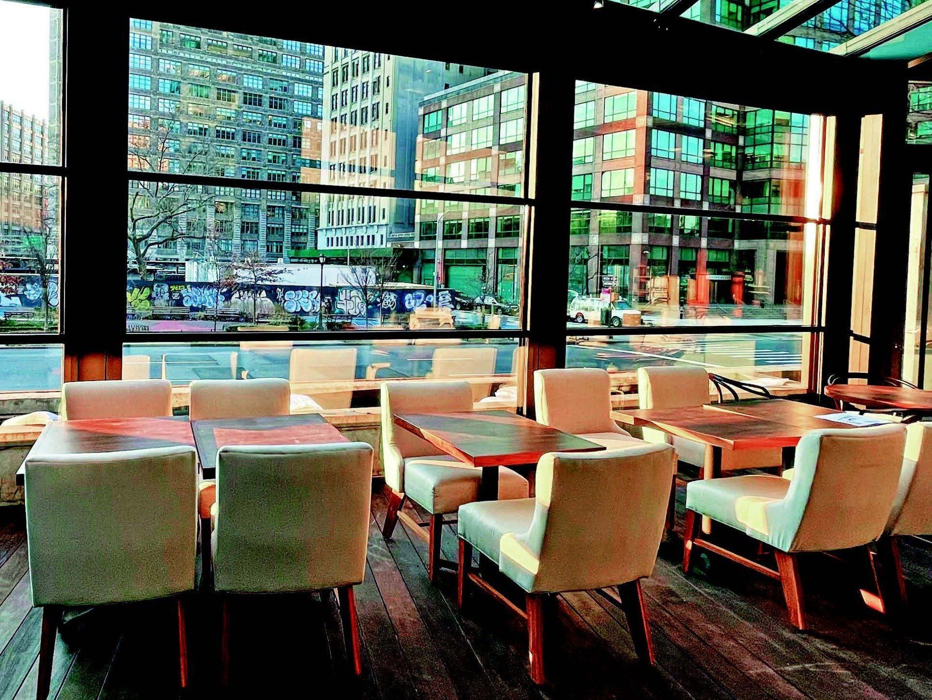 A restaurant with tables and chairs and a view of the city - Freehold, NJ - Awning Design Inc