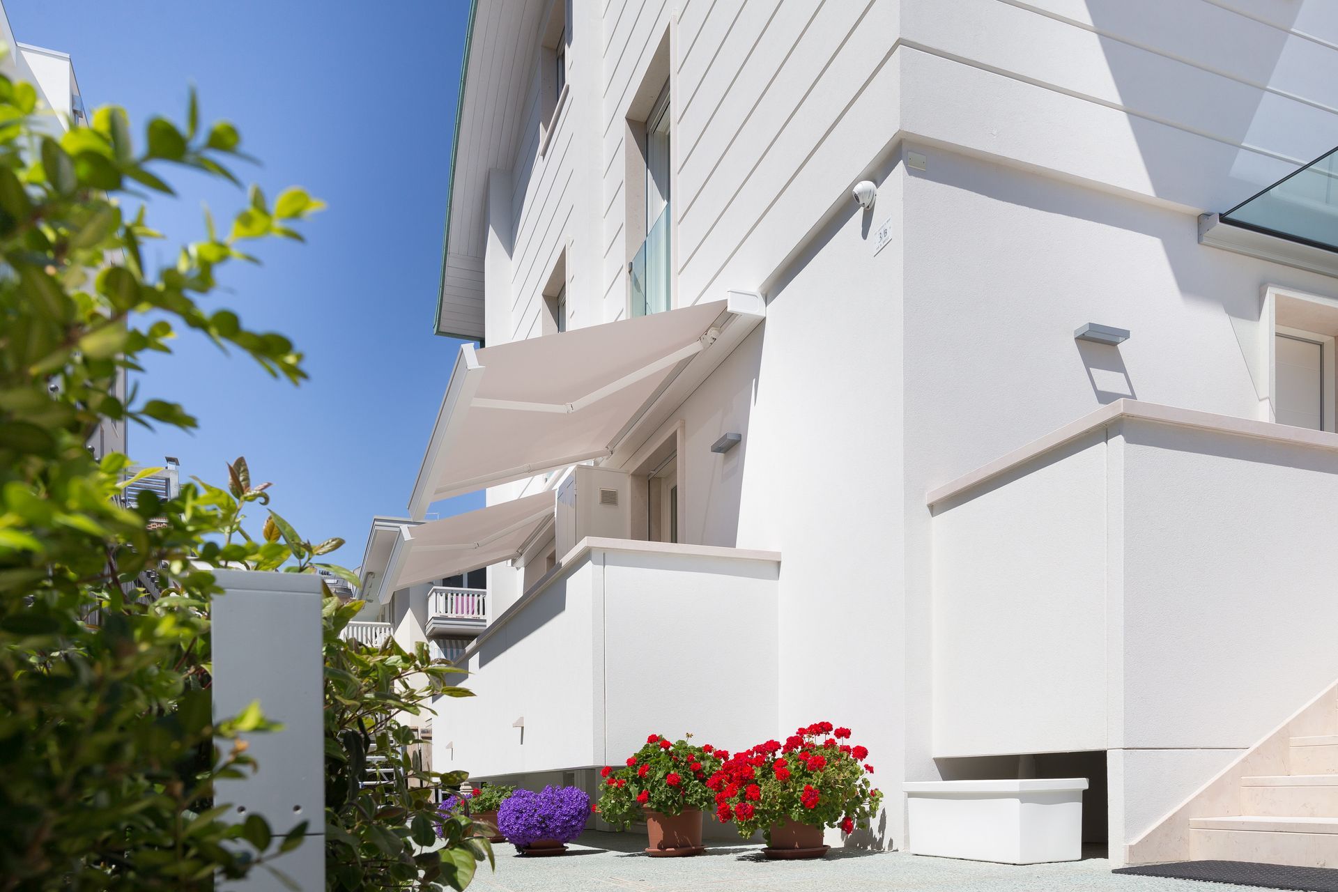 A white house with a white awning on the side of it - Freehold, NJ - Awning Design Inc