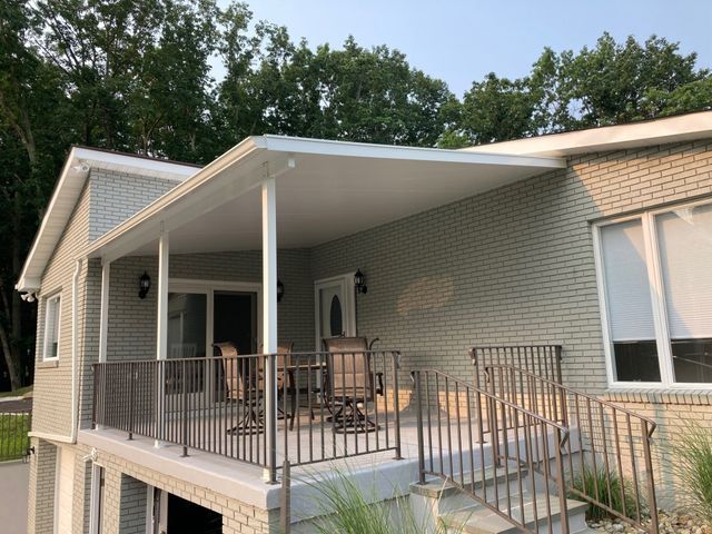 A white brick house with a large porch and stairs - Freehold, NJ - Awning Design Inc