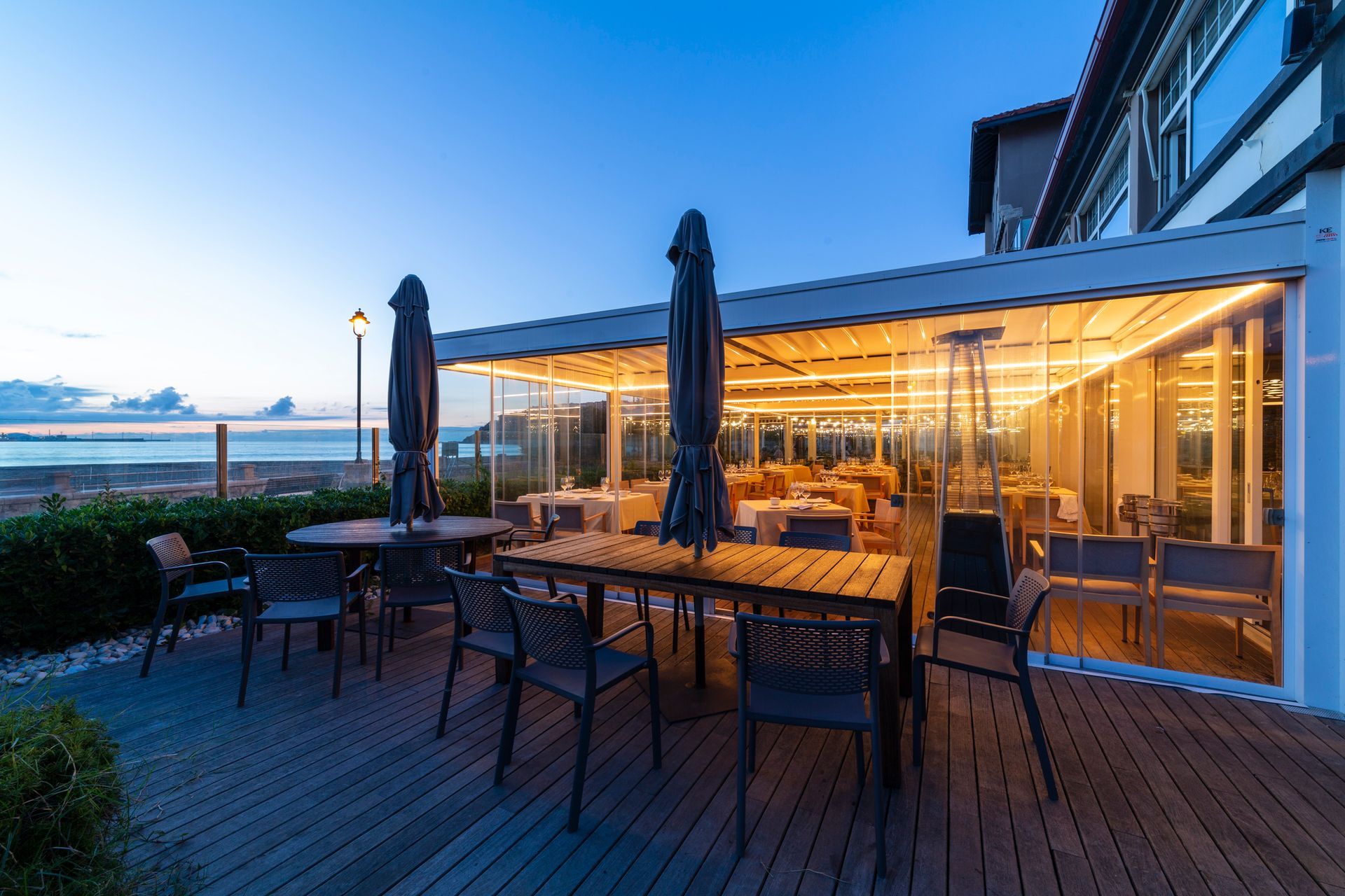 There are tables and chairs on the deck of a restaurant - Freehold, NJ - Awning Design Inc