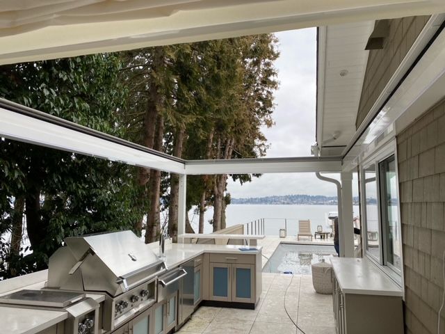 An outdoor kitchen with a grill and a view of the ocean - Freehold, NJ - Awning Design Inc