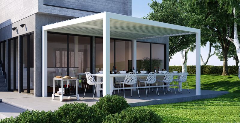 A white pergola with a table and chairs underneath it in front of a house - Freehold, NJ - Awning Design Inc