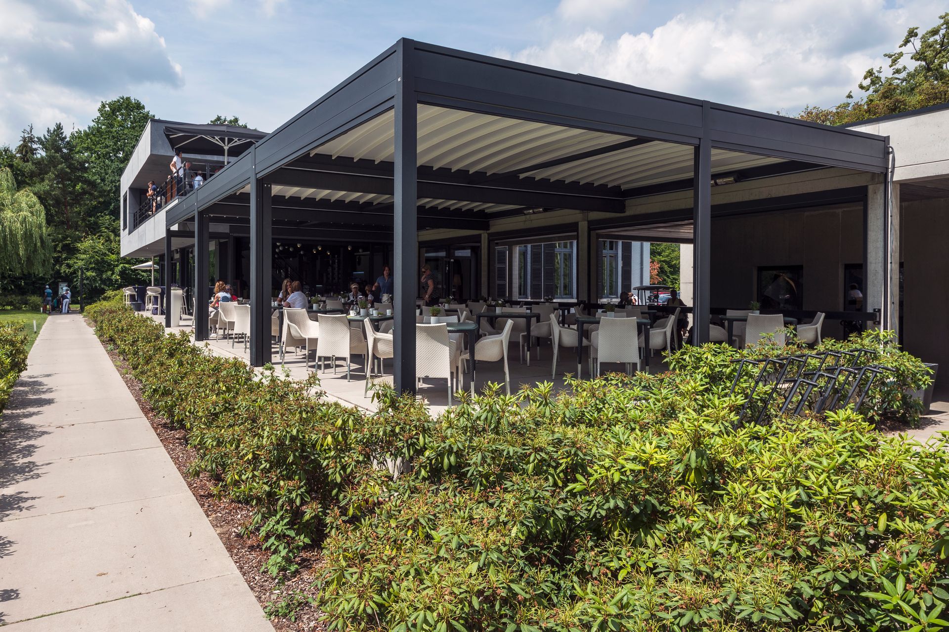 A restaurant with tables and chairs under a pergola - Freehold, NJ - Awning Design Inc